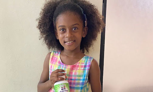 Millianny smiles while holding her bottle of Previnex Super Vites